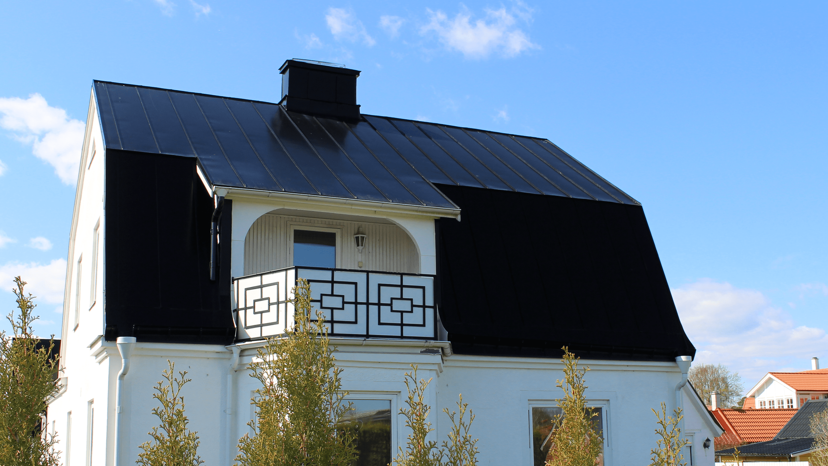 Svart aluminiumtak på vit trävilla